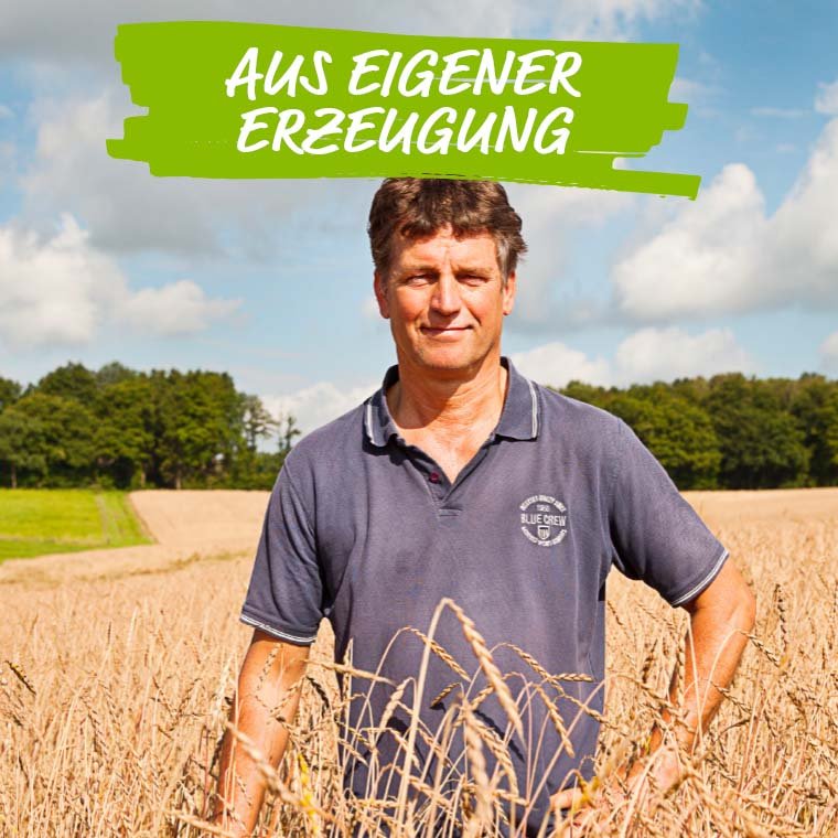 Das Foto zeigt Landwirt Konrad Mockenhaupt an einem Sommertag stehend im Getreidefeld. Angeboten werden Bio-Produkte wie Kartoffeln, Eier, Hähnchen, Wustwaren, Getreide und mehr aus eigener Erzeugung.